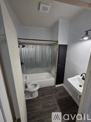 A bathroom with a toilet, sink, and bathtub.