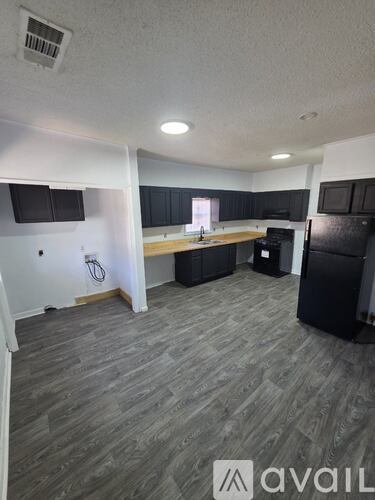 A kitchen area with a black fridge and a black oven.