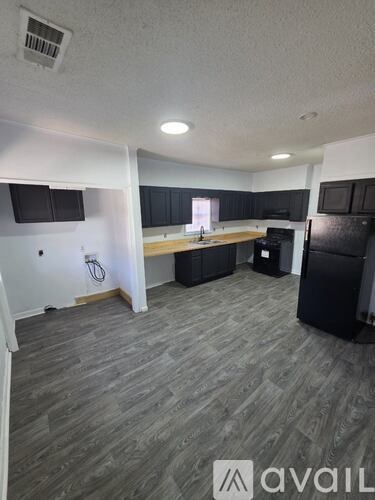 A kitchen area with a black fridge and a black oven.