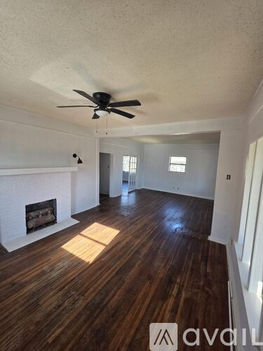 A room with wooden floors and a ceiling fan.