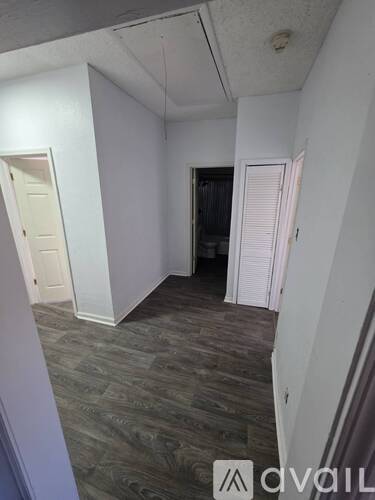 A room with a carpeted floor and a door on the left side.