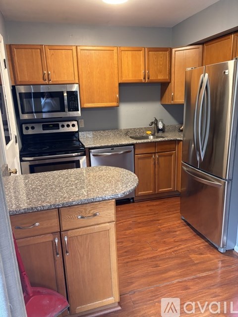 A kitchen with wooden cabinets and a granite countertop.