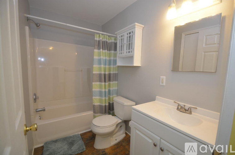 A bathroom with a toilet, sink, and shower.