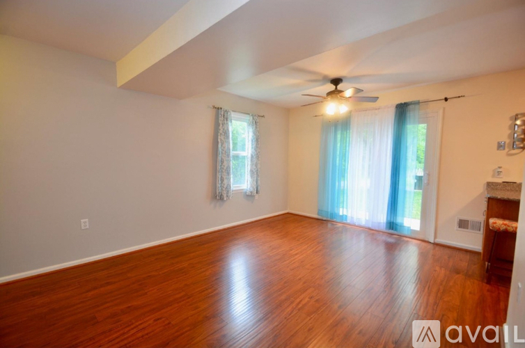 A room with wooden floors and a ceiling fan.