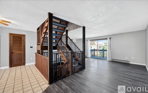 A spacious living room with a staircase leading to the upper floor.