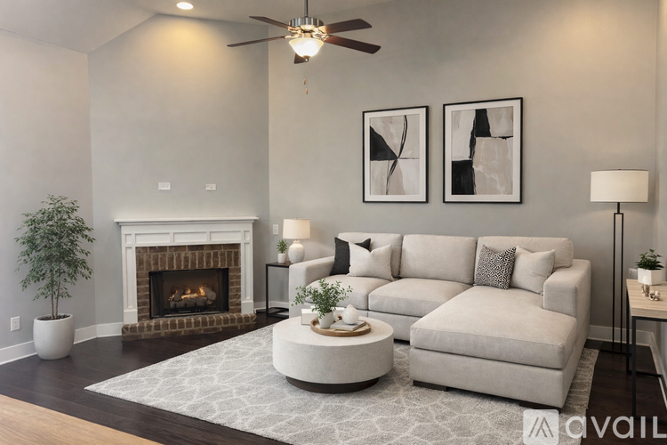 A living room with a fireplace, a couch, and a ceiling fan.
