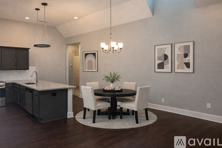 A modern kitchen with a dining table set for two.