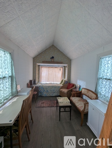 A room with a bed, a desk, and a chair.