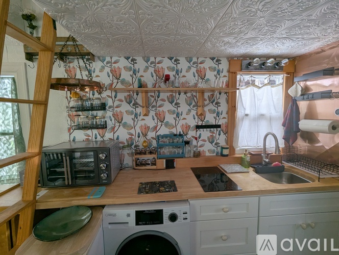 A kitchen with a washing machine and a wooden counter.