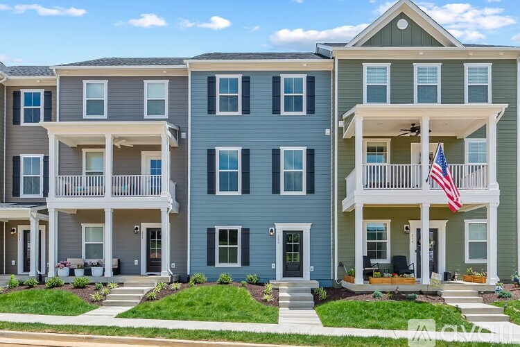 A row of townhouses with balconies and front yards.