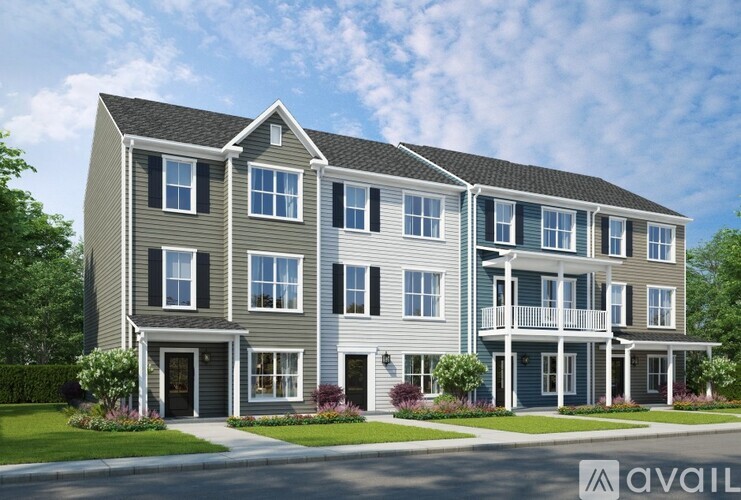 A modern two-story apartment building with a balcony on the second floor.