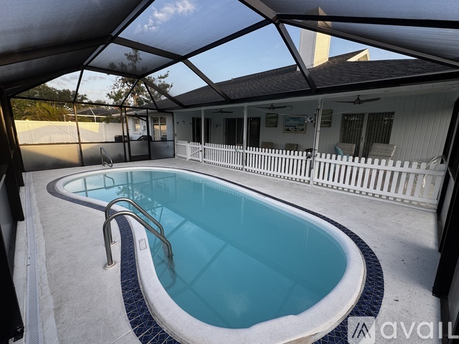 A small indoor pool with a white fence surrounding it.