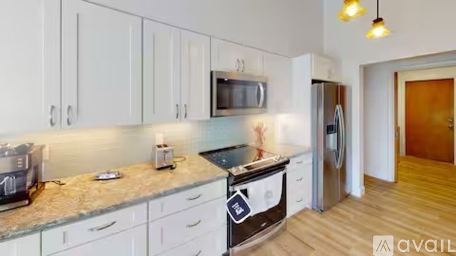 A kitchen with white cabinets and a granite countertop.