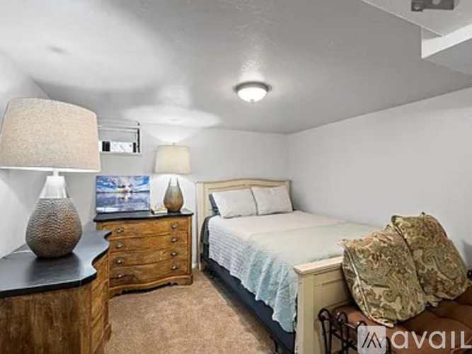 A bedroom with a bed, nightstand, and lamp.