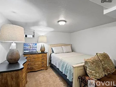 A bedroom with a bed, nightstand, and lamp.