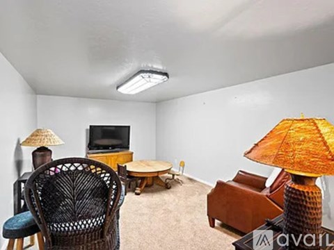 A living room with a television, chairs, and a table.