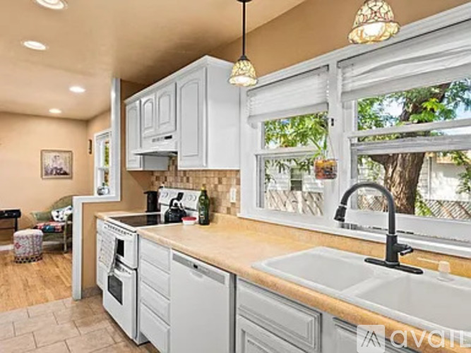 A kitchen with white cabinets and a wooden countertop.
