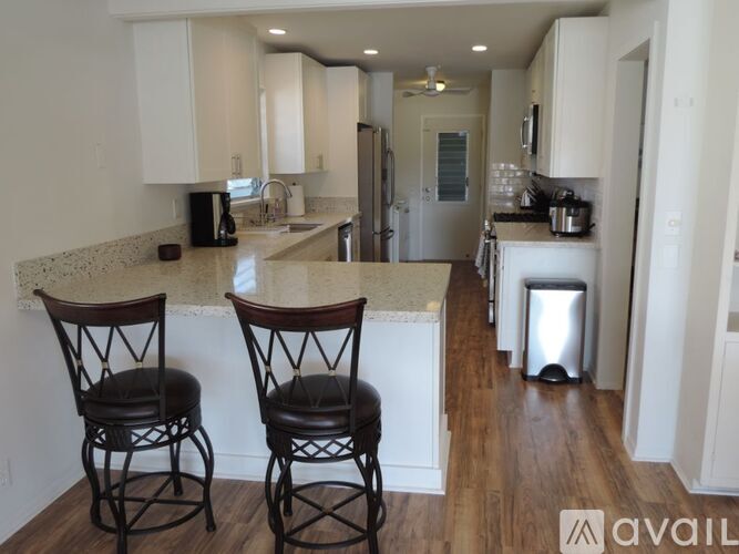 Two chairs are placed in front of a kitchen island.