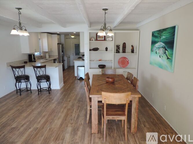 A dining room with a wooden table and chairs.