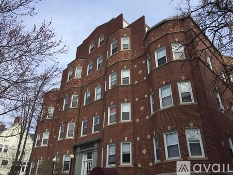 A tall red brick building with the word "AVAILABLE" on the front.