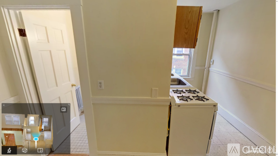 A white door is on the left and a white stove is in the middle of the room.