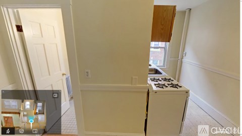 A white door is on the left and a white stove is in the middle of the room.