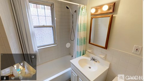 A white bathroom with a white sink and a window.