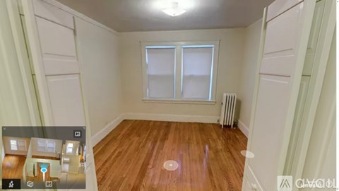 A room with wooden flooring and a window.