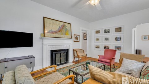 A living room with a fireplace and a painting above it.
