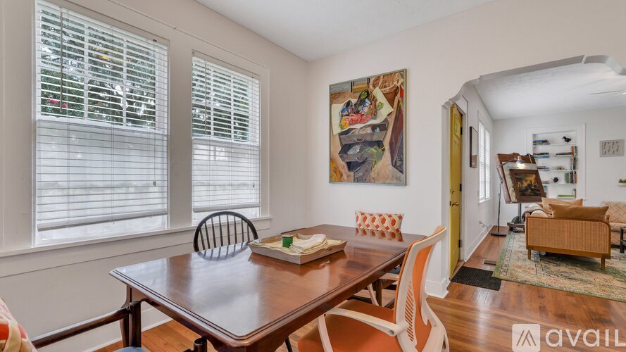 A dining room with a wooden table and chairs.