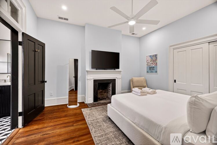 A bedroom with a fireplace and a television.