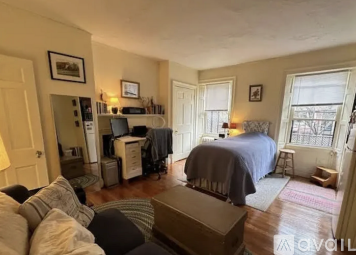 A living room with a couch, a bed, and a television.