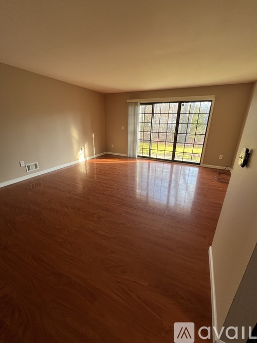 A room with wooden flooring and a sliding glass door.