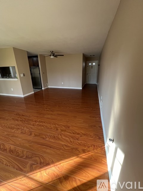 A room with wooden flooring and a ceiling fan.