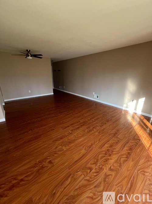 A room with wooden flooring and a ceiling fan.