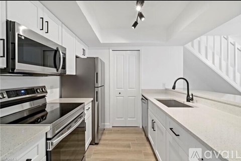 A kitchen with white cabinets and stainless steel appliances.