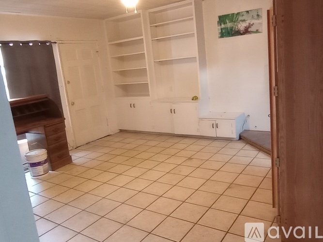 A room with white tiled flooring and a wooden door.