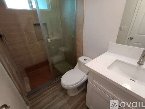 A room with white tiled flooring and a wooden door.