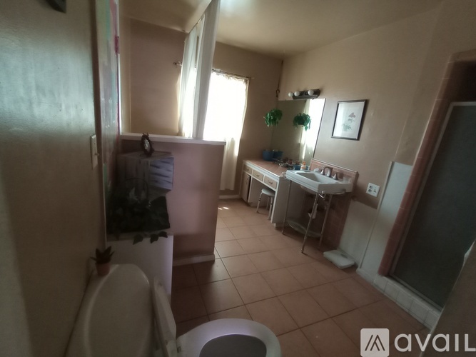 A bathroom with a toilet, sink, and mirror.