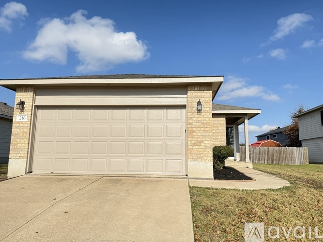 A house with a beige garage door and a brick facade.