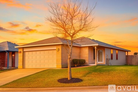 A house with a beige garage door and a brick facade.
