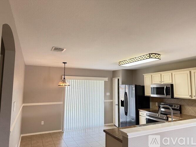 A kitchen with a refrigerator, microwave, and oven.