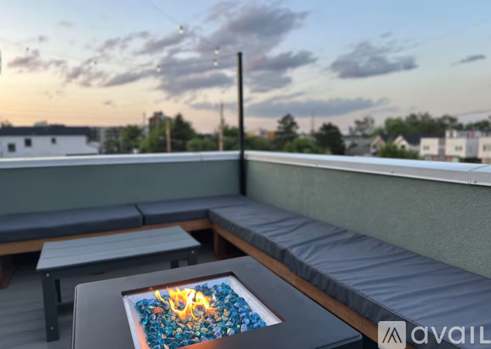 A hot tub on a balcony with a view of the sky and buildings.