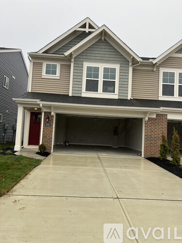 A two-story house with a garage and a driveway.