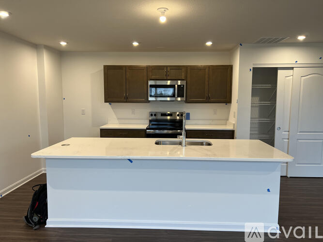 A kitchen with white countertops and brown cabinets.