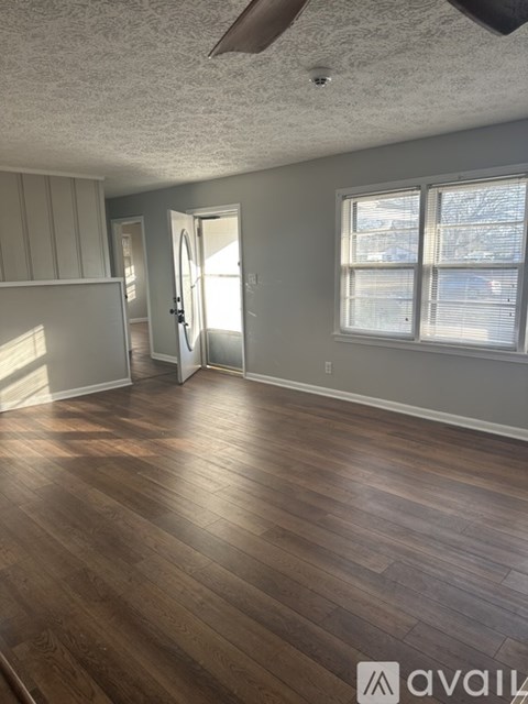 A room with wooden flooring and a ceiling fan.