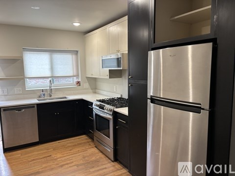 A kitchen with wooden floors and white walls.