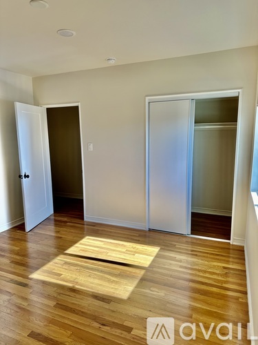 A room with a wooden floor and two white doors.