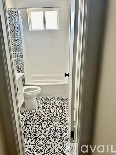 A bathroom with a toilet, a bathtub and a tiled floor.