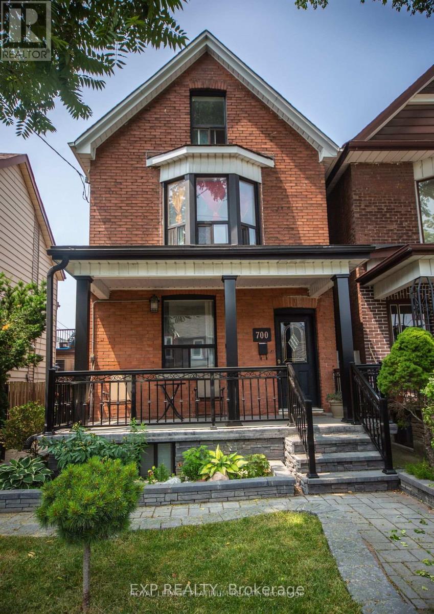 A brick house with a black door and a small porch.